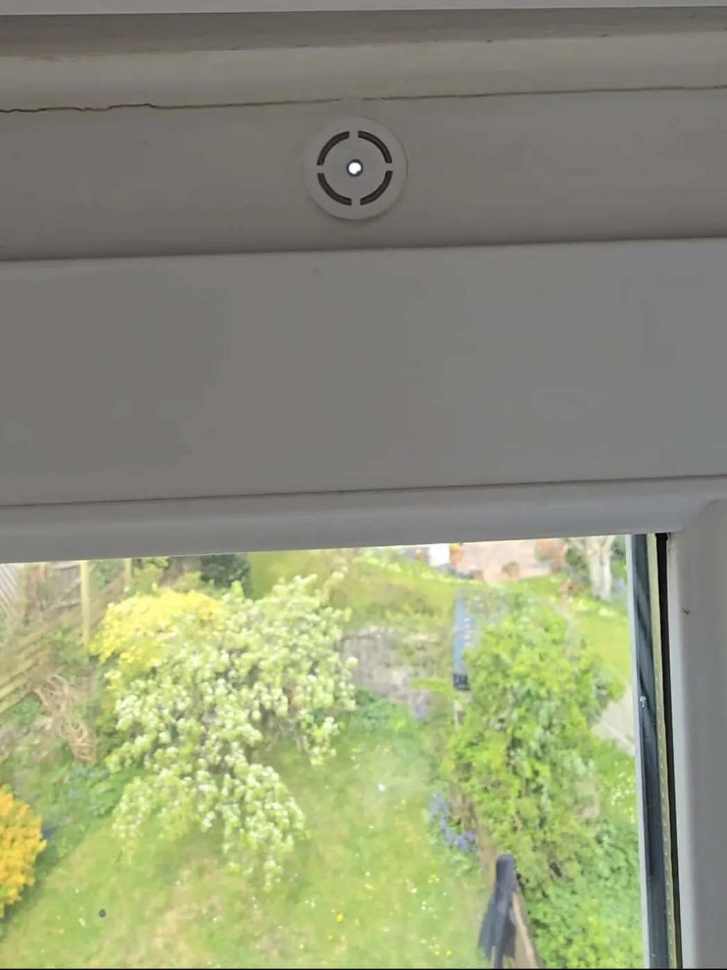 The Active Trickle Vent fitted at the head of a uPVC window, providing wind-powered cross-ventilation